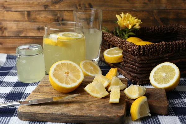 Bodegón con jugo de limón y limones en rodajas sobre fondo de madera — Foto de Stock