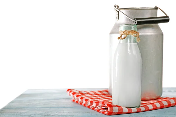 Retro kan voor melk en glazen fles van melk op houten tafel, op witte achtergrond — Stockfoto