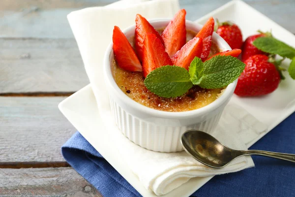 Creme brulee tatlısı peçeteye renk ahşap arka plan üzerinde taze çilek Çilek ile — Stok fotoğraf