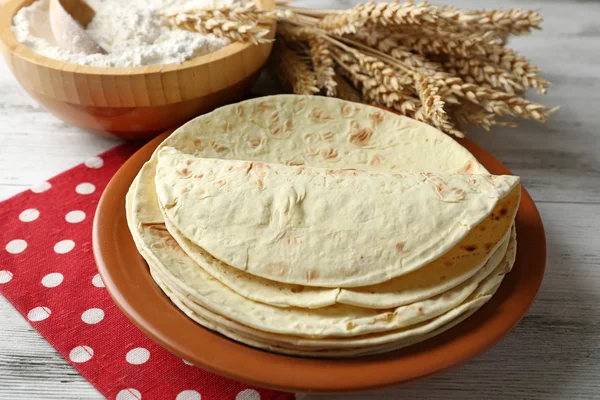 Montón de tortilla casera de harina de trigo integral en plato, sobre fondo de mesa de madera — Foto de Stock