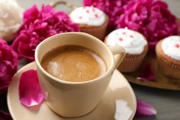 Composition with cup of coffee, muffins and peony flowers on wooden background — Stock Photo, Image