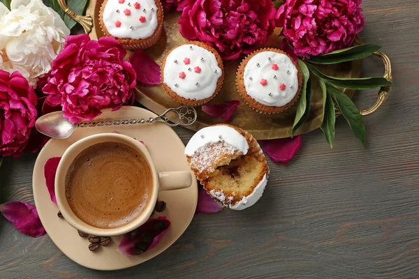 Composition avec tasse de café, muffins et fleurs de pivoine sur fond de bois — Photo