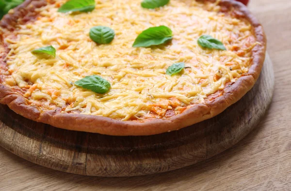 Pizza de queso con albahaca en la mesa de cerca —  Fotos de Stock