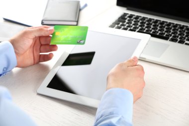 Kredi kartı ve tablet işyeri arka planda tutan adam