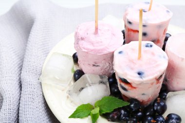 Gri peçete, closeup üzerinde beyaz tabak içinde siyah kuş üzümü ile tatlı dondurma