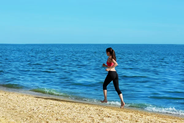 年轻女子在海滩上慢跑 — 图库照片