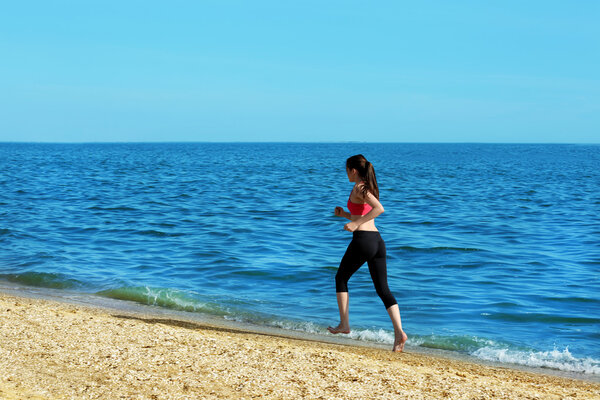 Young woman jogging on beach