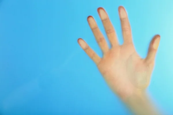 Female hand behind wet glass — Stock Photo, Image