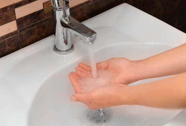 Lavarse las manos en el lavabo en el baño — Foto de Stock