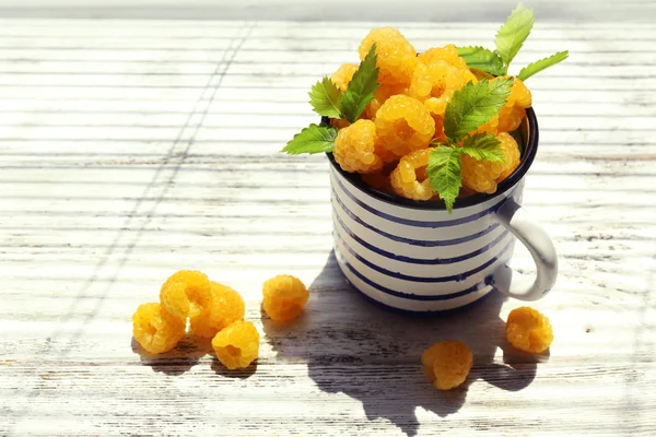 Cup of yellow raspberries on wooden background — Stock Photo, Image