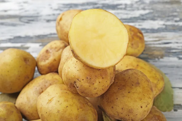 Batatas jovens na mesa de madeira perto — Fotografia de Stock