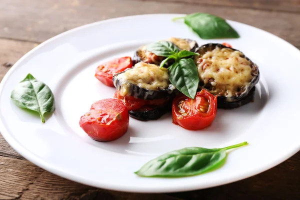 Patlıcan kiraz domates ve peynirle ahşap masa, closeup üzerinde beyaz tabakta yemek — Stok fotoğraf