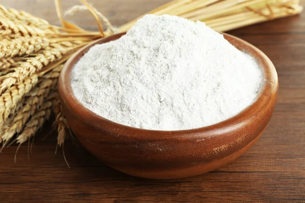 Whole flour in bowl with wheat ears — Stock Photo, Image