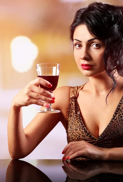 Hübsche junge Brunet mit Weinglas auf leicht verschwommenem Hintergrund — Stockfoto