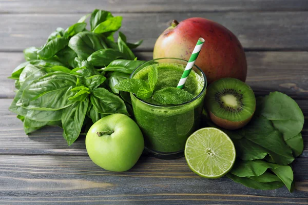 Groene gezond vruchtensap met groenten en kruiden op houten tafel close-up — Stockfoto