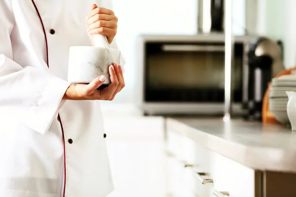 Cocine las manos con mortero con hierbas sobre fondo brillante —  Fotos de Stock