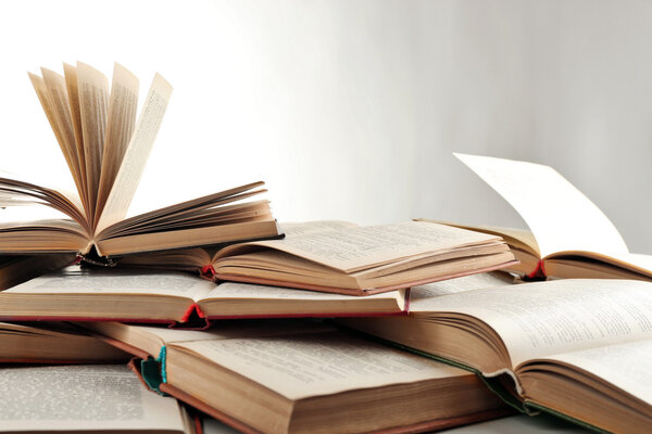 Многие открытые книги изолированы по белому
