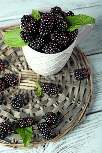 Un mucchio di more dolci con menta in tazza sul tavolo da vicino — Foto Stock