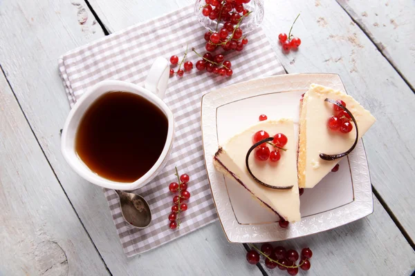 Leckerer Käsekuchen mit Beeren und einer Tasse Tee auf dem Tisch aus nächster Nähe — Stockfoto