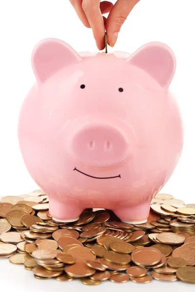 Pink piggy bank with coin in female hand isolated on white — Stock Photo, Image