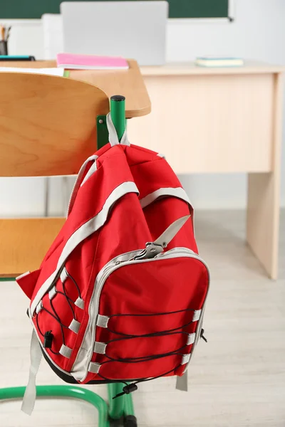 Backpack with knife in classroom — Stock Photo, Image