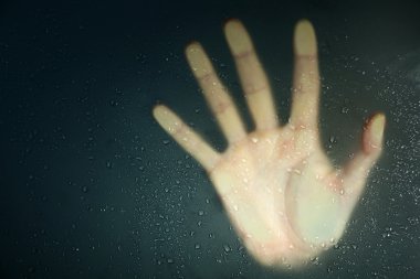 ıslak cam arkasında el