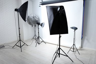 Empty photo studio with lighting equipment clipart