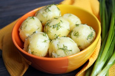 Masada bir kapta yeşillikleri ile haşlanmış patates yakın çekim
