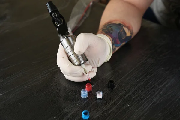 Татуировщик на работе крупным планом — стоковое фото
