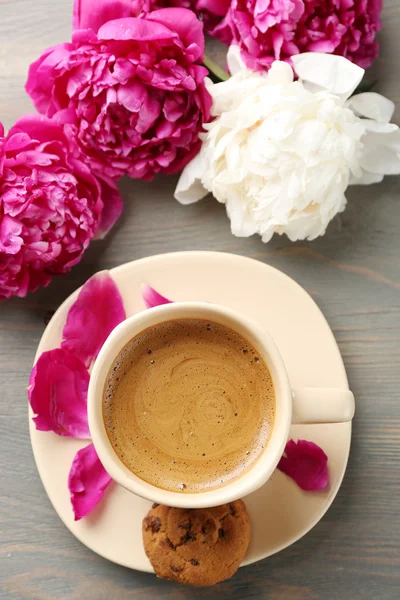 Composizione con tazza di caffè e fiori di peonia su fondo di legno — Foto Stock