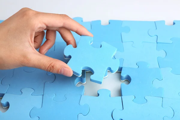 Hand placing last piece of puzzle — Stock Photo, Image