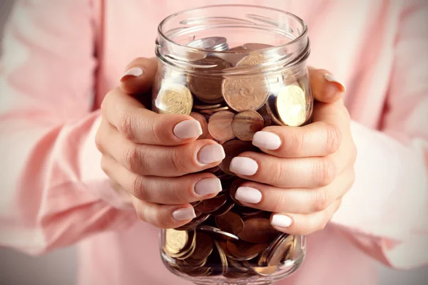 Woman holding money jar with coins — Stock Photo, Image