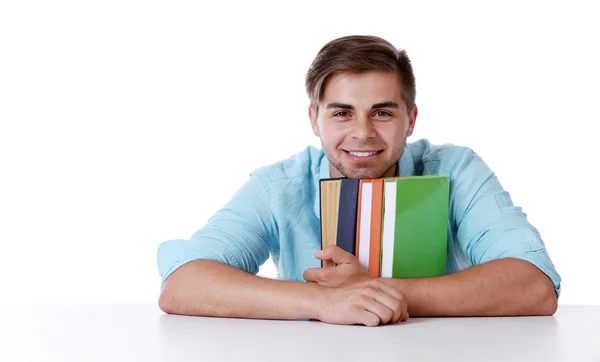 Молодой человек с книгами за столом — стоковое фото