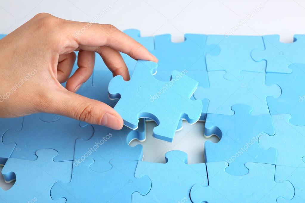 hand placing last piece of puzzle