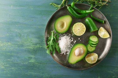 Dilimlenmiş avokado, salatalık / biber ve limon kireç ahşap arka plan üzerinde