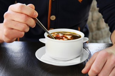 borsch ve ahşap masa, tatlı kaşık ile erkek el ile beyaz kase