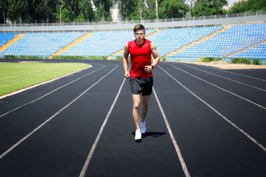 Genç adam stadyum üzerinde koşu