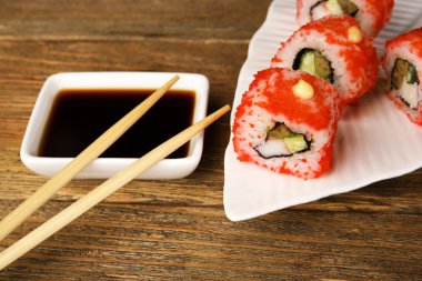 Ahşap masa üzerinde sos ve sopa ile rulo yakın çekim