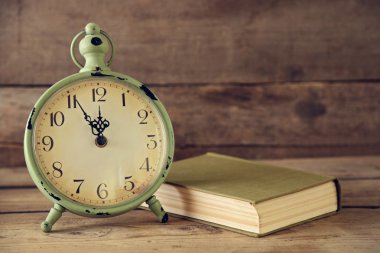 Rustik ahşap arka plan üzerinde saat ve vintage kitaplar