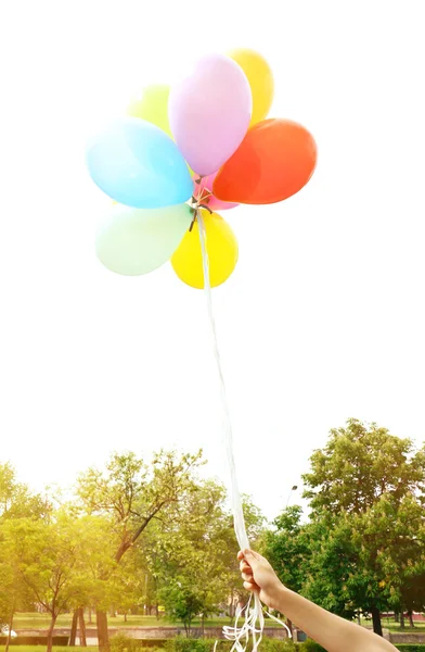 Balloons in hand, outdoors — Stock Photo, Image
