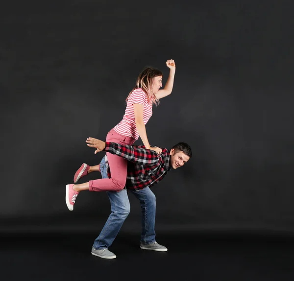 Emotional young couple on black background — Stock Photo, Image