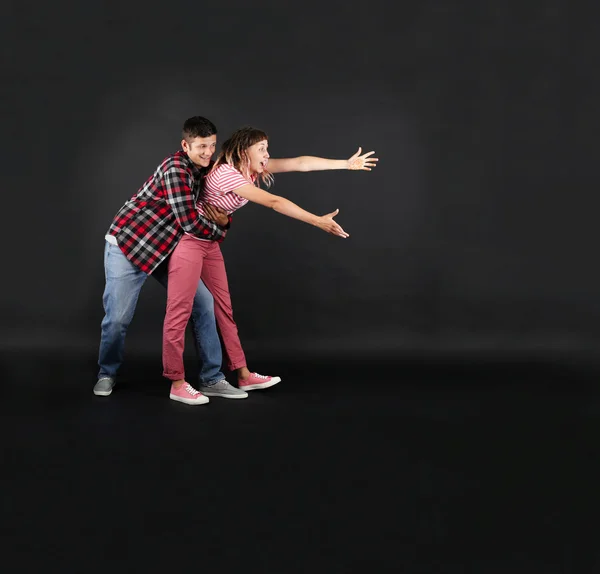 Emotional young couple on black background — Stock Photo, Image