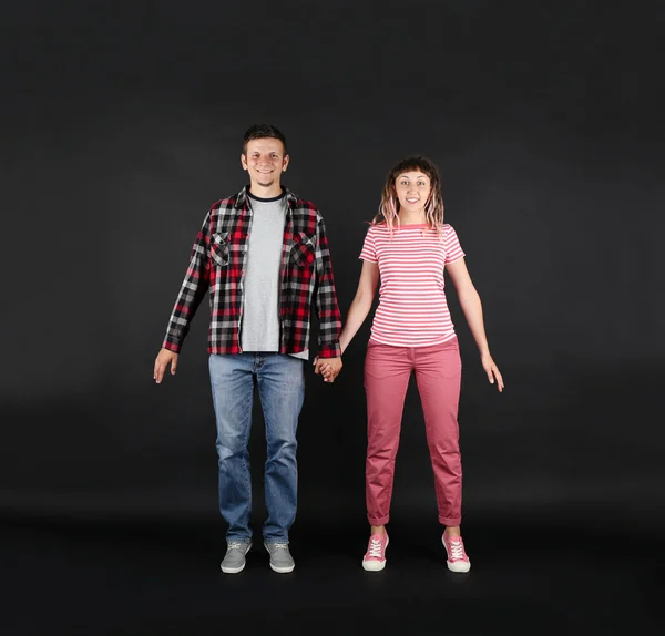 Emotional young couple on black background — Stock Photo, Image