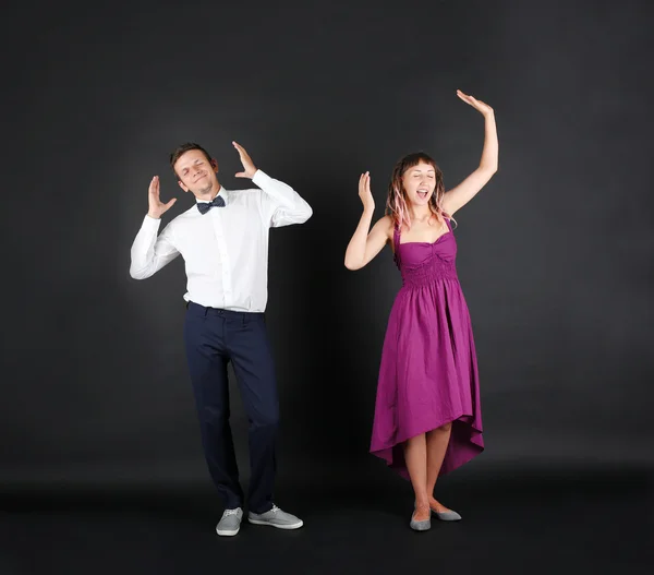 Emotional young couple on black background — Stock Photo, Image