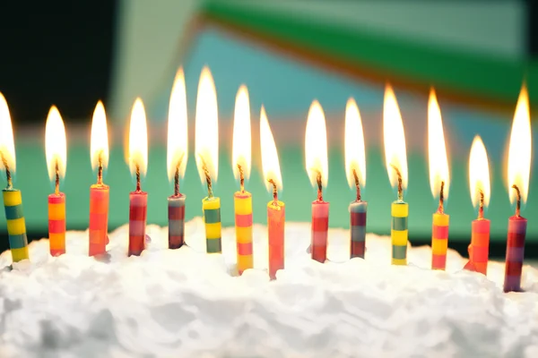 Verjaardagscake met kaarsen op kleurrijke achtergrond — Stockfoto