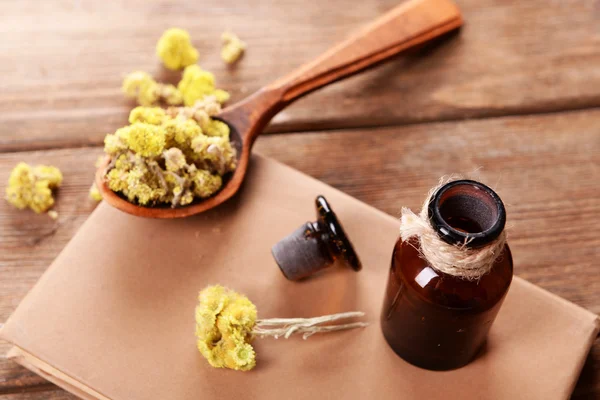 Livro velho com flores secas e garrafa na mesa de perto — Fotografia de Stock