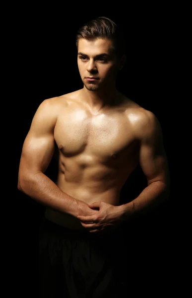 Muscle young man on dark background — Stock Photo, Image