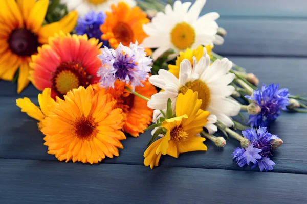 Flores silvestres brilhantes na mesa de madeira, close-up — Fotografia de Stock