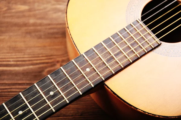 Akustická kytara na dřevěném pozadí — Stock fotografie