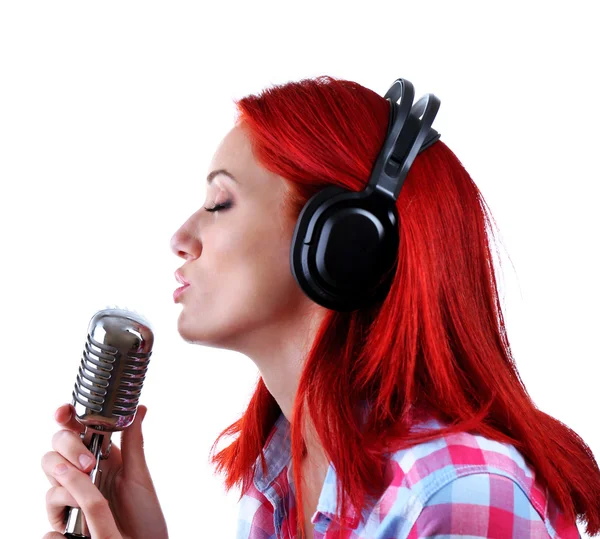 Beautiful young woman singing with microphone isolated on white — Stock Photo, Image